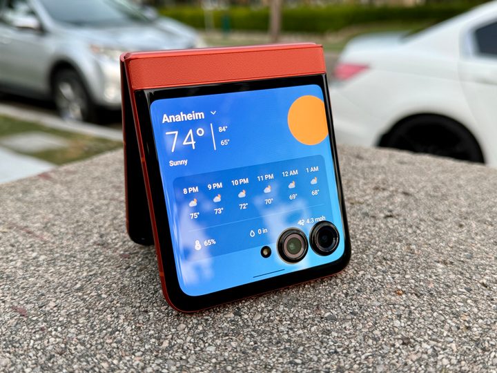 Motorola Razr 2024 in Spritz Orange showing the weather on cover display.