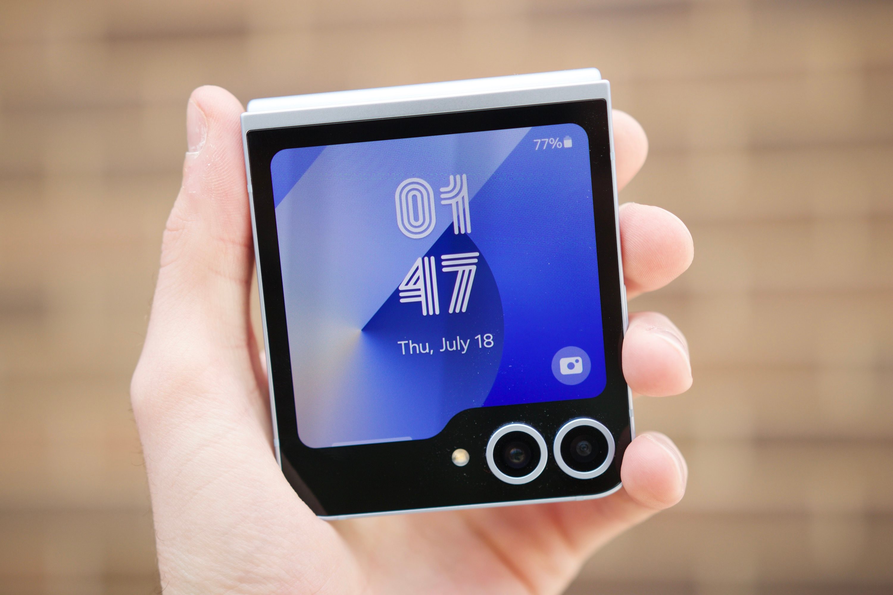 Someone holding the Samsung Galaxy Z Flip 6, showing the cover screen.