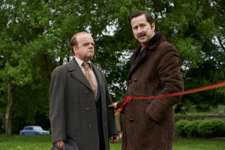 Two men stand at a crime scene in The Long Shadow.