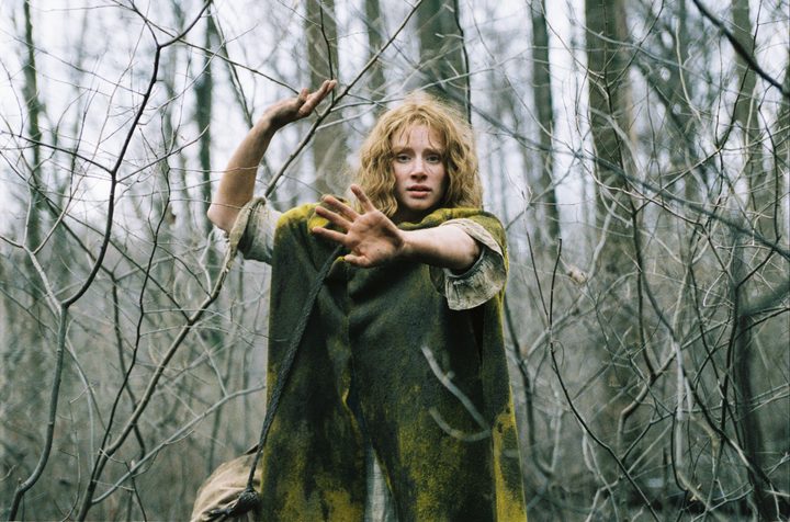 A girl walks through the woods in The Village.
