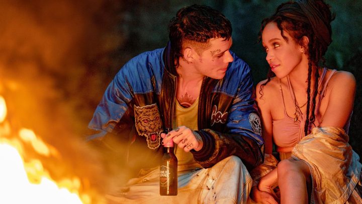 Bill Skarsgård and FKA Twigs as Eric and Shelly sitting next to a bonfire in The Crow