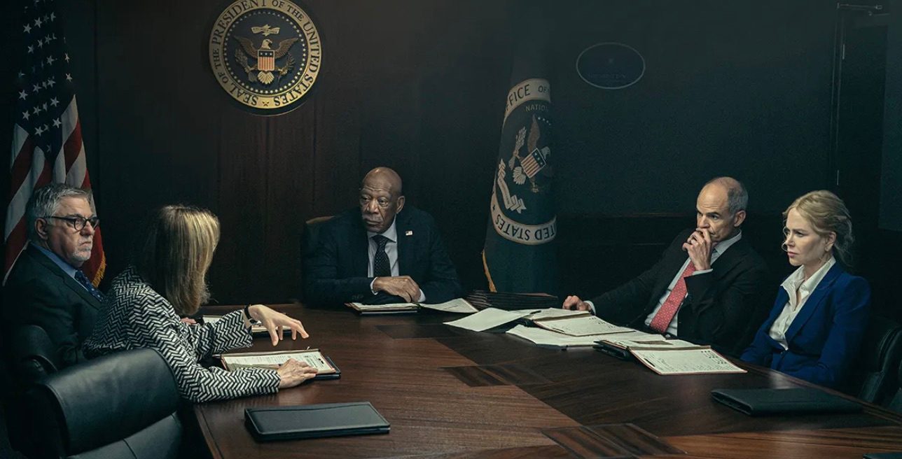 A group of people sit around a table and ponder.