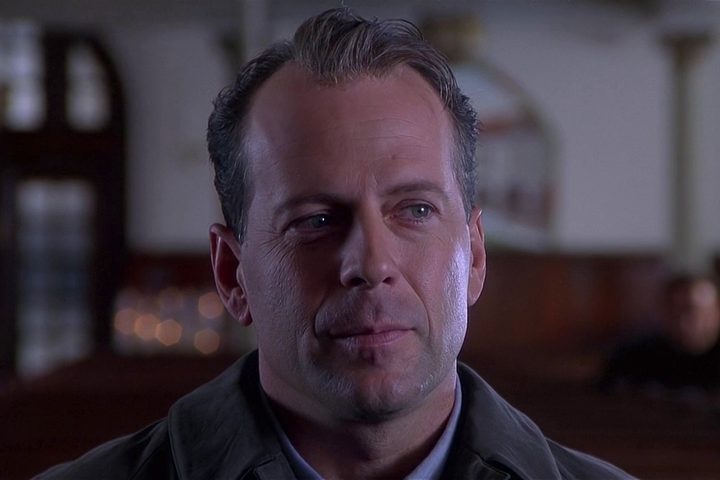 Bruce Willis looks to the side teary-eyed in The Sixth Sense.