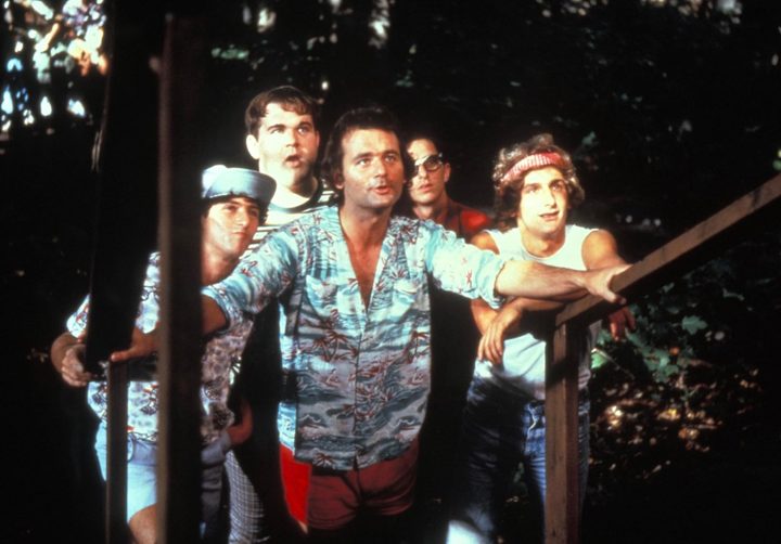 Bill Murray and a group of teens stand at the bottom of the stairs.