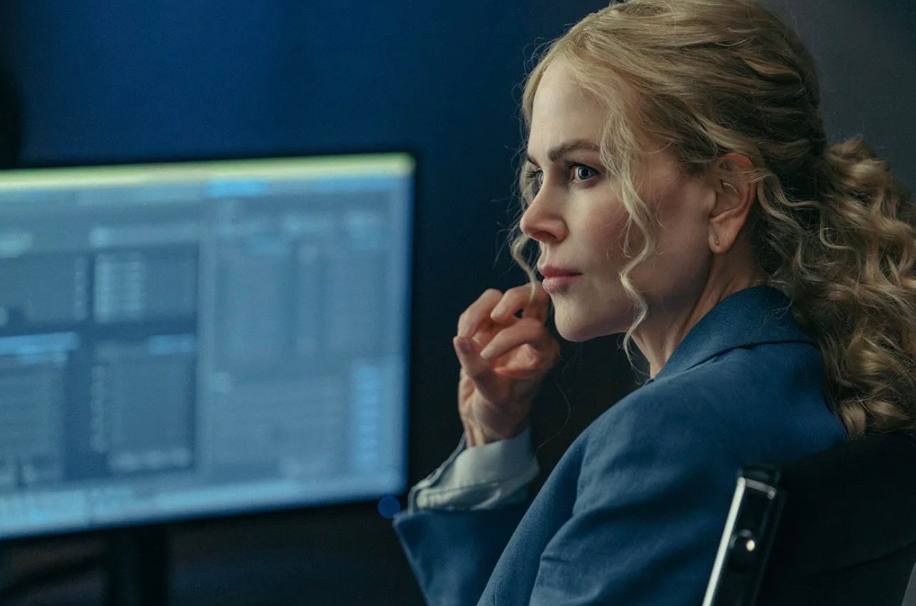 A woman sits at a desk and stares.