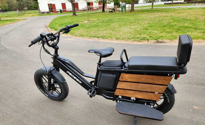 Pedego Cargo left side view of seats, storage, and handlebar controls.