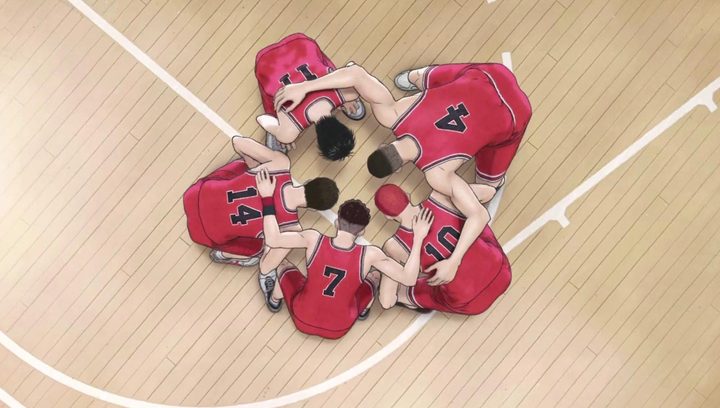 A group of basketball players huddle together.
