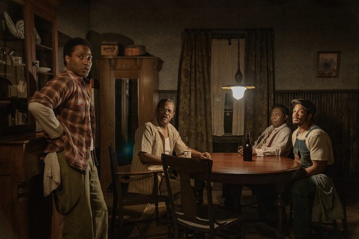 One man stands up as three people behind him sit down.
