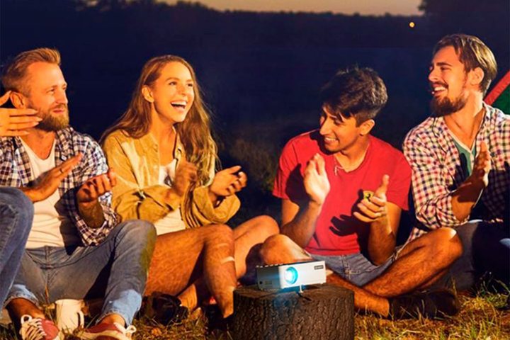 A group of people sitting around a Vankyo Leisure 470 Pro Native 1080p Mini Projector.