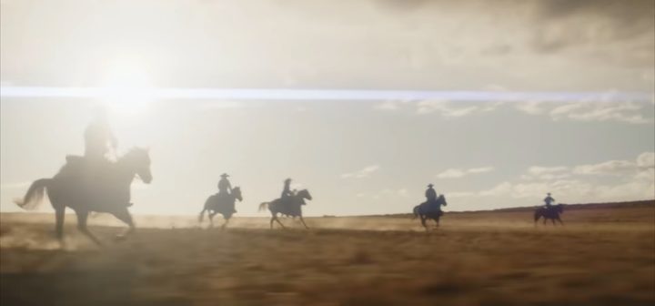 Men riding across a field on horses with the sun shining in the sky in "Wyatt Earp and the Cowboy War."