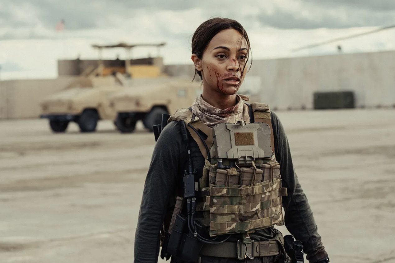Zoe Saldana stares with blood on her face.
