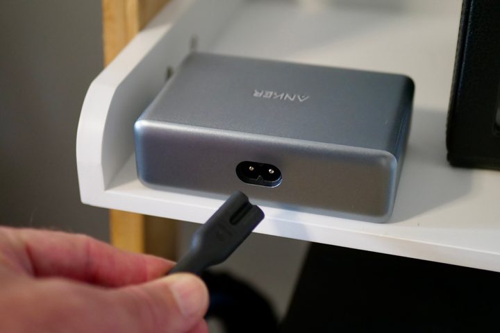A person plugging in the Anker Supercharged Multi-port Desktop Charging Station.