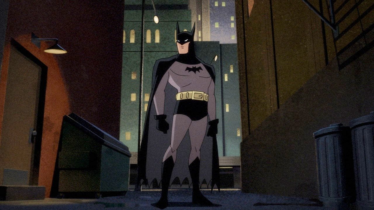 Batman stands in a dark alley in Batman: Caped Crusader.