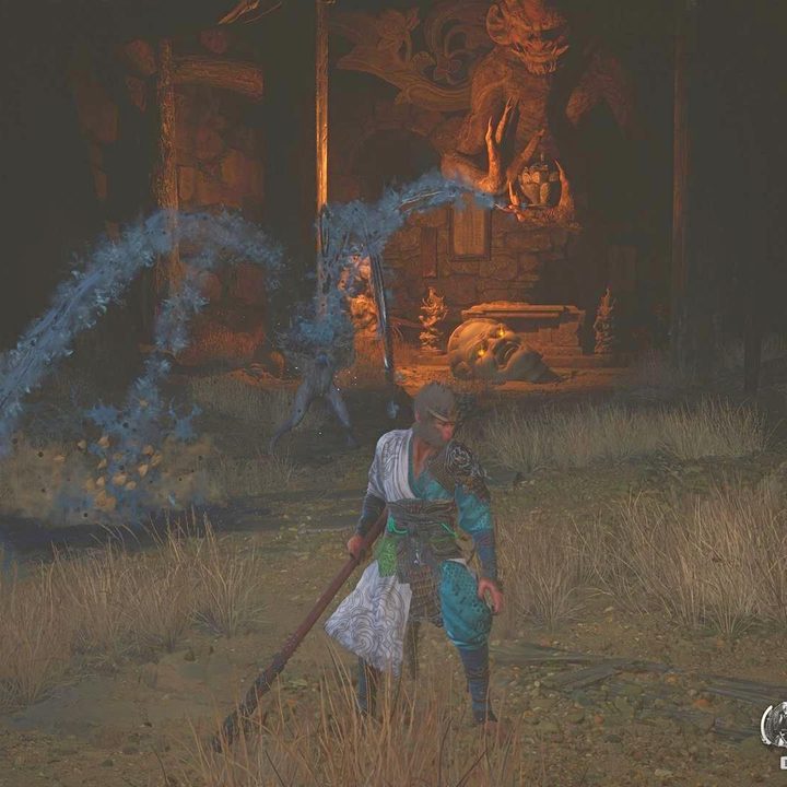 The image shows the player approaching a statue head inside a cave.