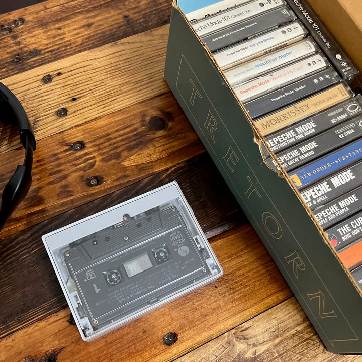 The Fiio CP13 portable cassette playe next to a Tretorn shoebox full of cassettes.