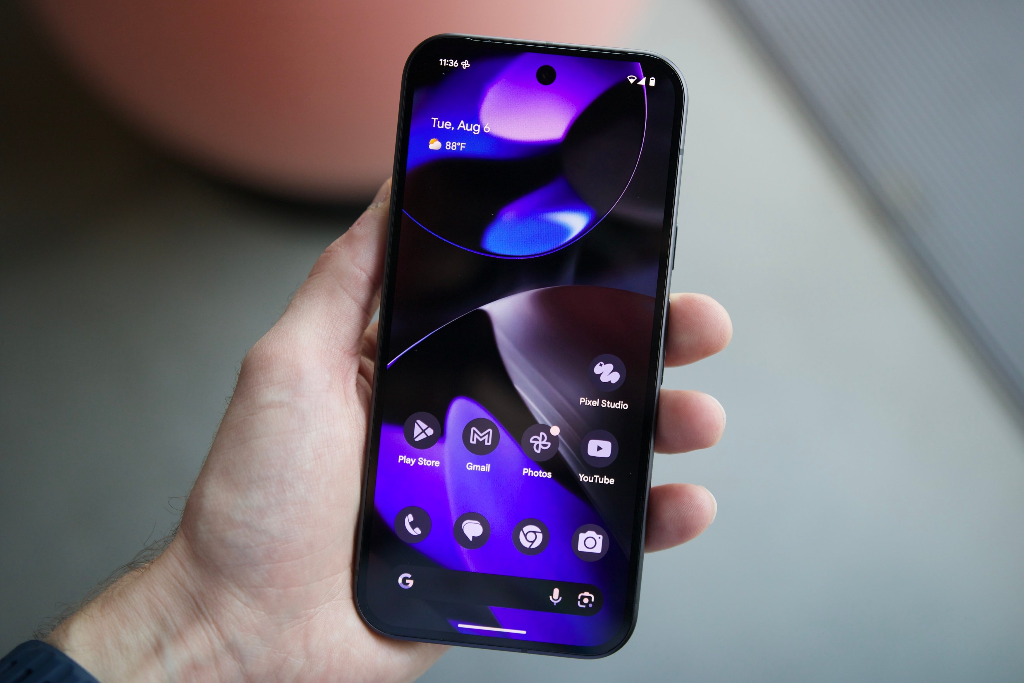 Someone holding the Google Pixel 9 with the display turned on.