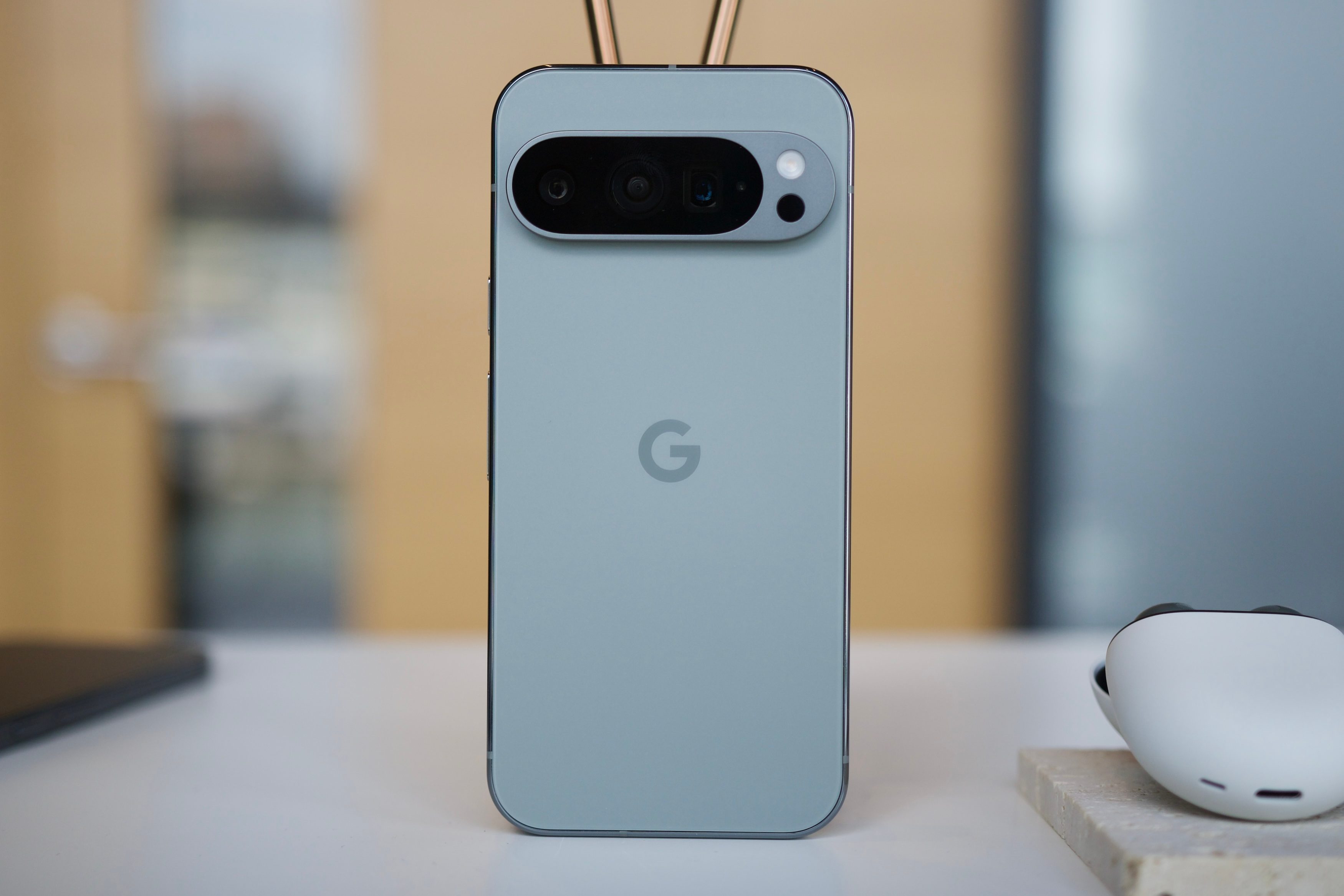 The Google Pixel 9 Pro standing upright on a table.