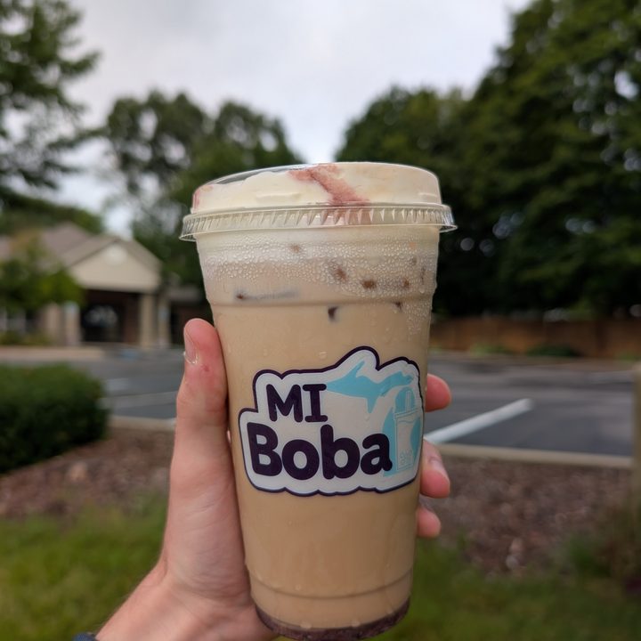 A photo of someone holding cold brew in a plastic cup, taken with the Google Pixel 9 Pro XL.