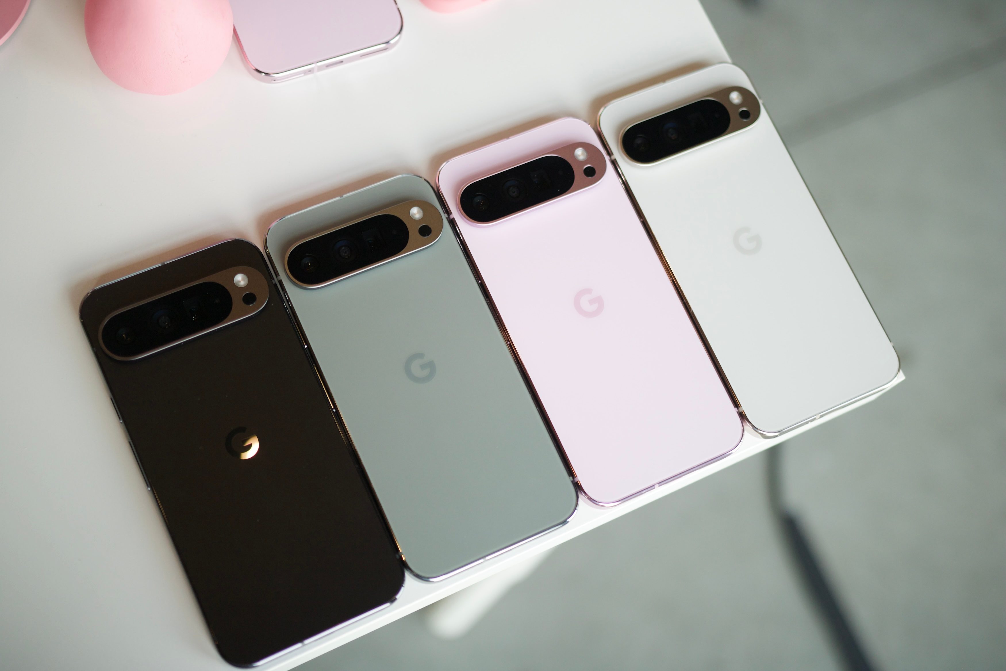 All four colors of the Google Pixel 9 Pro XL laying next to each other on a white table.