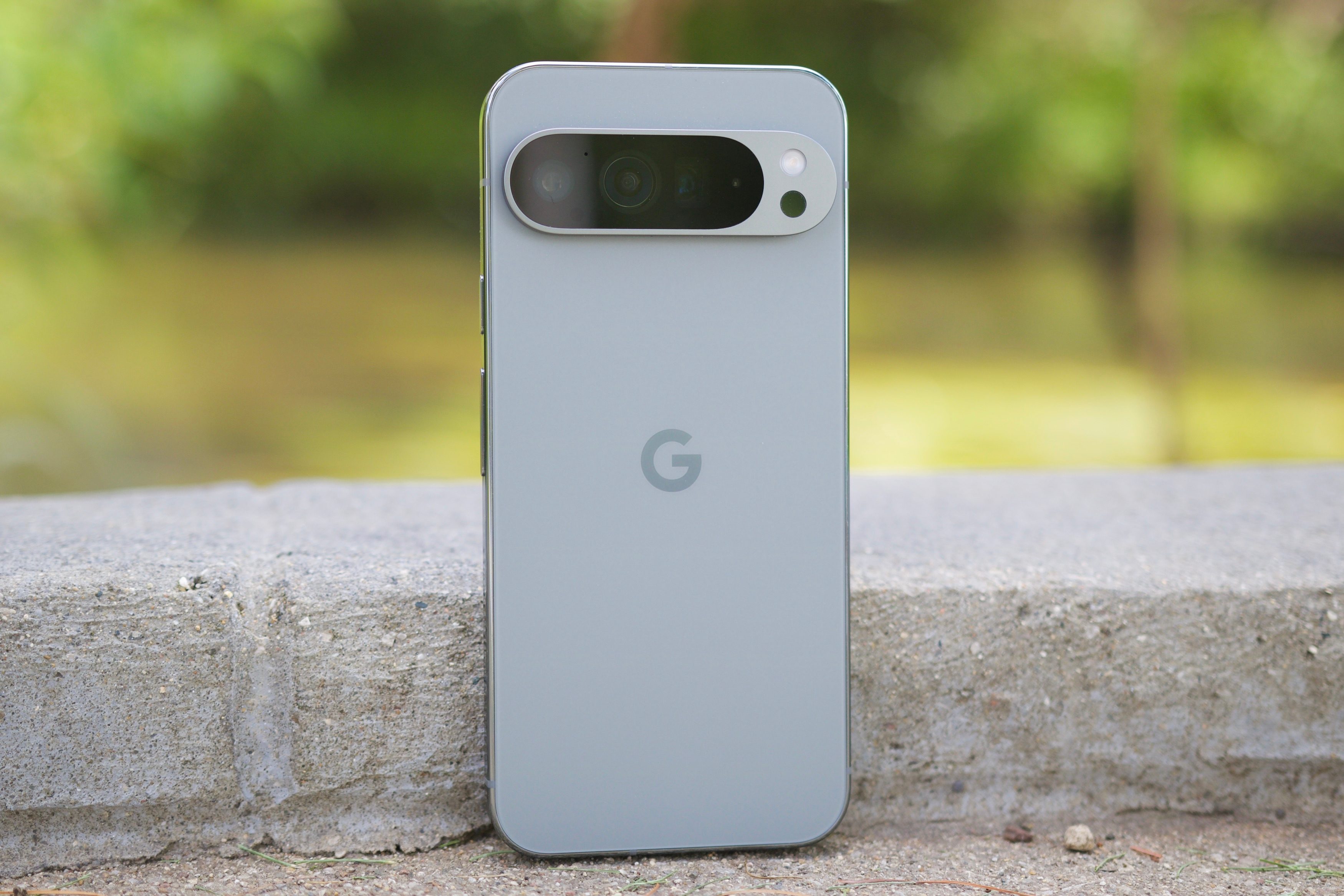 The Google Pixel 9 Pro XL sitting upright outside.