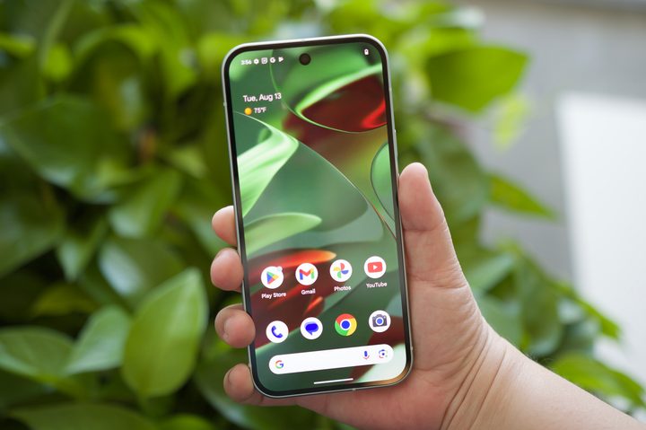 Someone holding the Google Pixel 9 with the screen on.