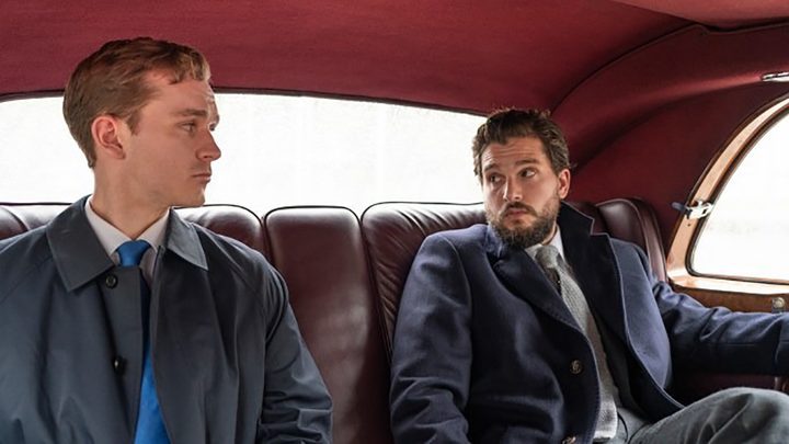 Kit Harington sitting in the back seat of a fancy car with another man in a scene from season 3 of Industry on Max.