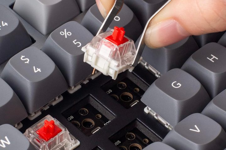 A person using tweezer to swap keys on the Keychron Q3 QMK/VIA Mechanical Keyboard.