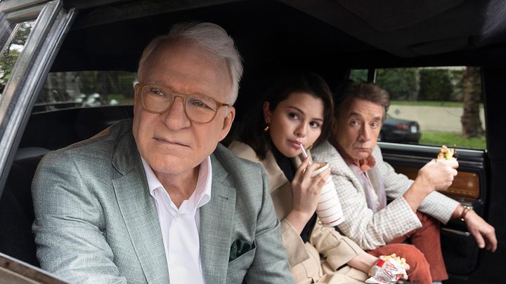 Charles, Oliver, and Mabel in the backseat of a car looking out the window on Only Murders in the Building.