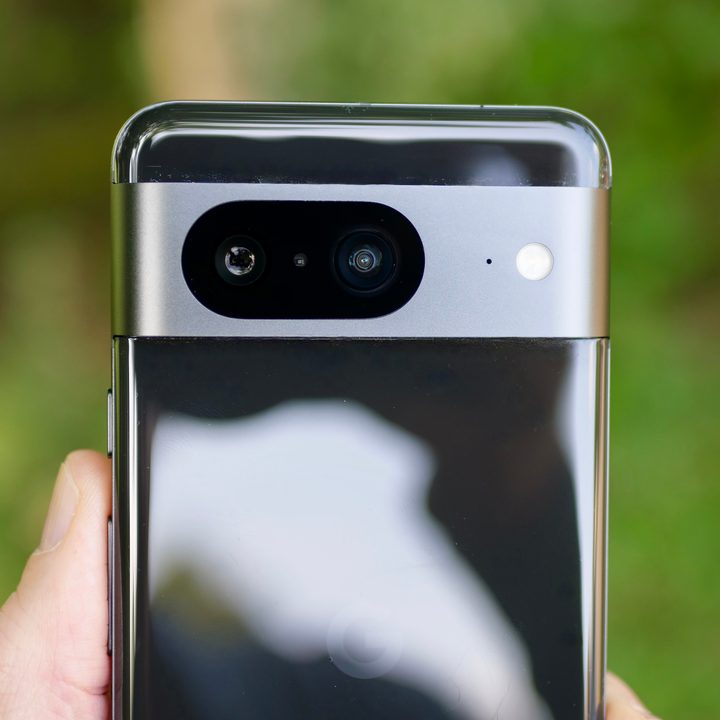 A person holding the Google Pixel 8, showing the camera.