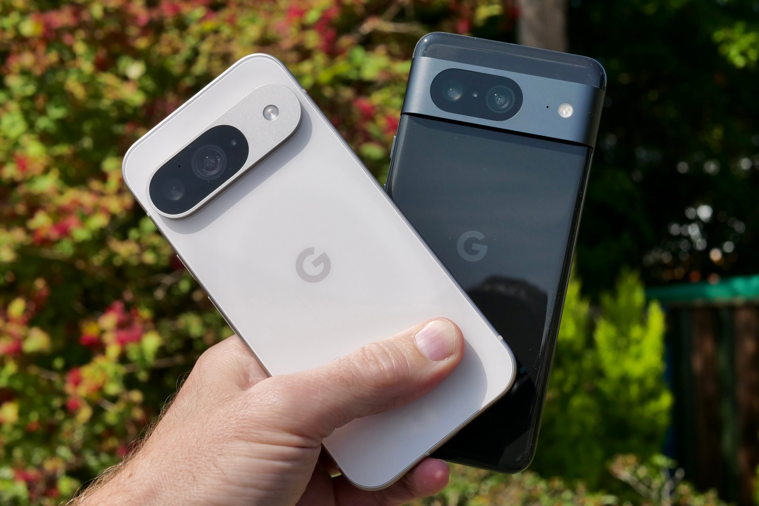 Una persona que sostiene Google Pixel 9 y Google Pixel 8.