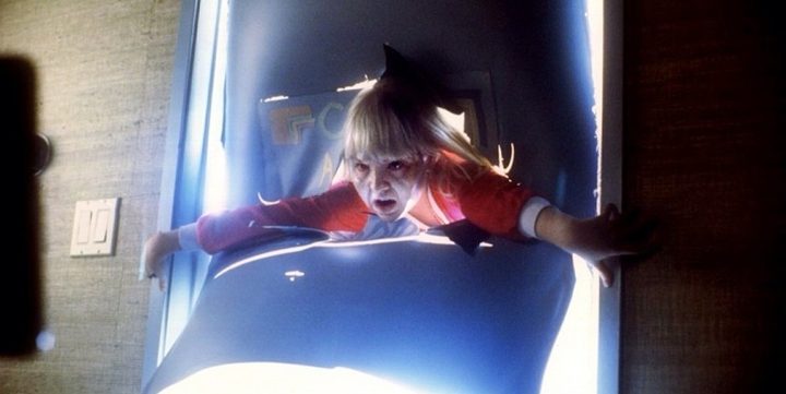 A demon child emerges from a door in Poltergeist III.
