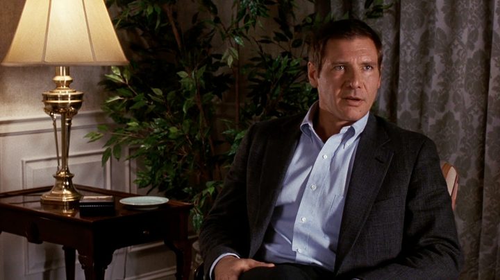 Harrison Ford sits down and stares.