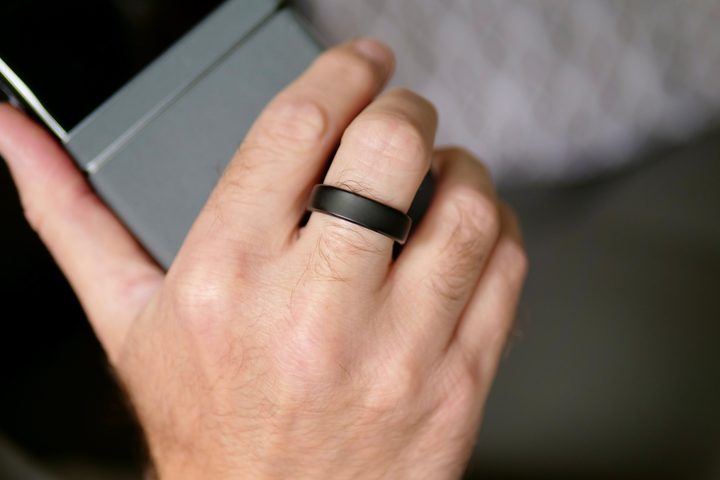 A person wearing the RingConn Gen 2 and holding a phone.