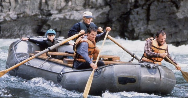 Four people ride a raft in The River Wild.