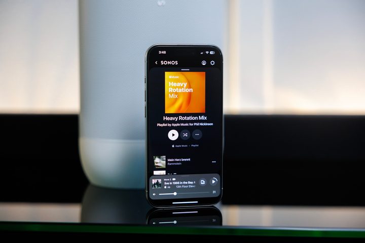 The Sonos app on an iPhone in front of a Sonos Move 2 speaker.