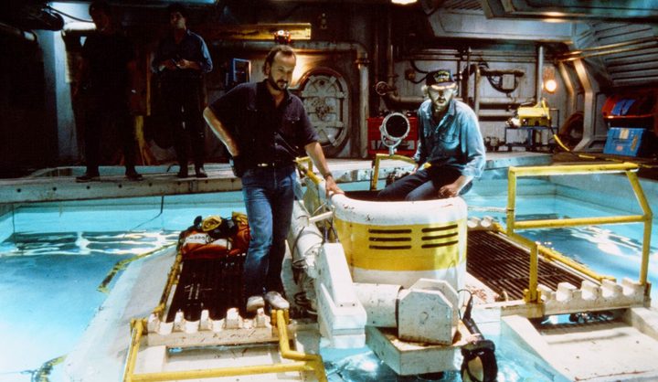 Two men look at sea equipment in The Abyss.