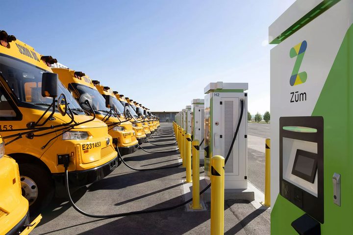 A fleet of electric school buses charging.