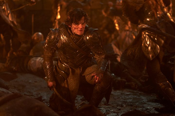 Elrond kneels on a battlefield in The Lord of the Rings: The Rings of Power season 2.