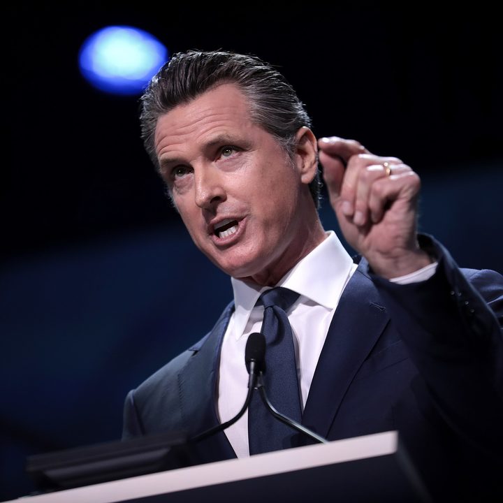 California Governor Gavin Newsom speaking at a lecturn.