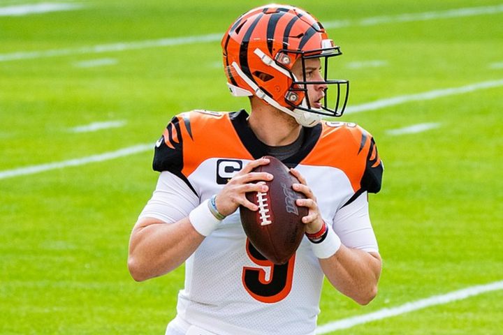 Joe Burrow holds a football and sets up to throw.