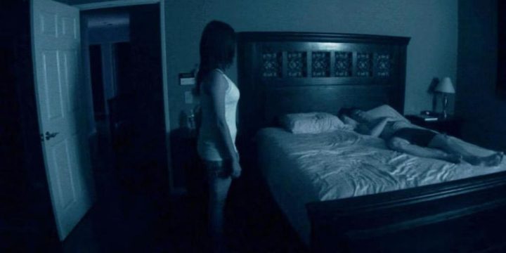 Katie stands over Micah in bed in Paranormal Activity
