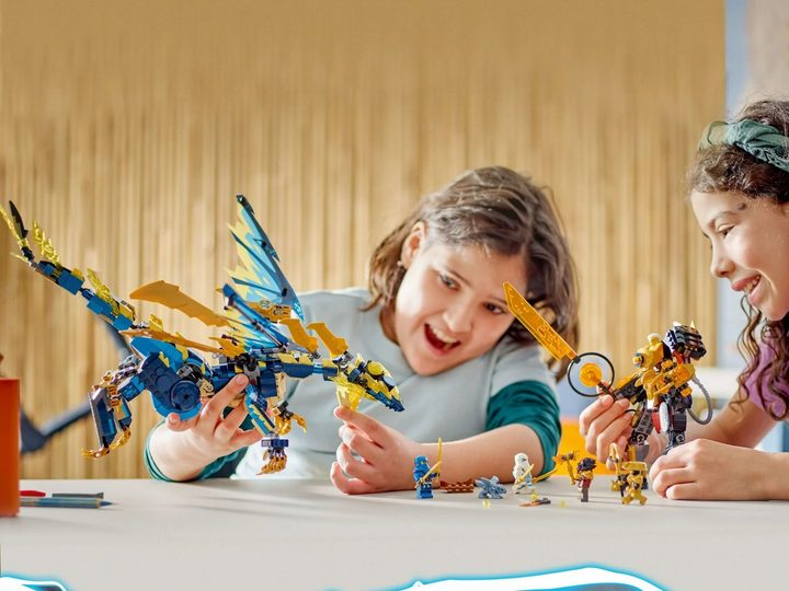 Two kids playing with the giant Lego Ninjago Elemental Dragon vs. The Empress Mech kit.