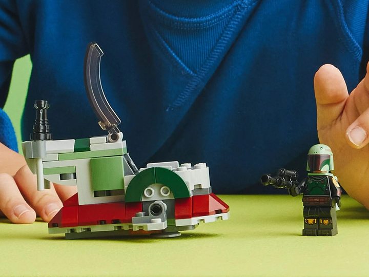 A child playing with the Lego Star Wars Boba Fett's Starship Microfighter Set.