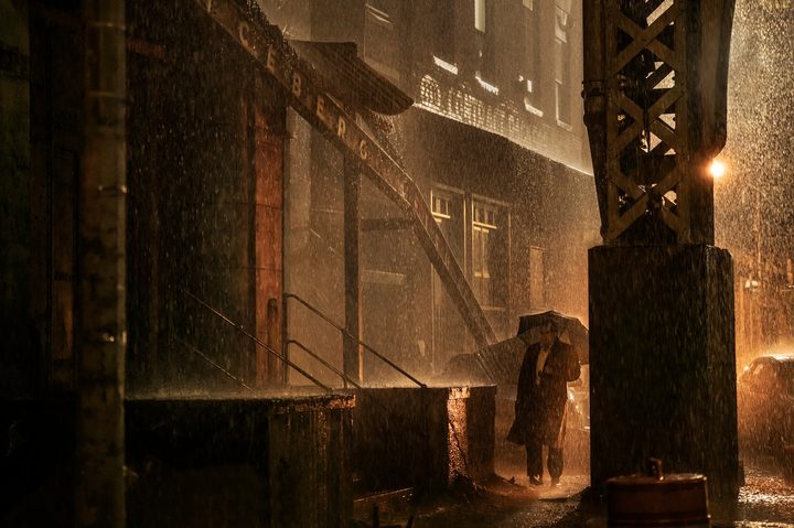 Oz walks with an umbrella in the rain in The Penguin.