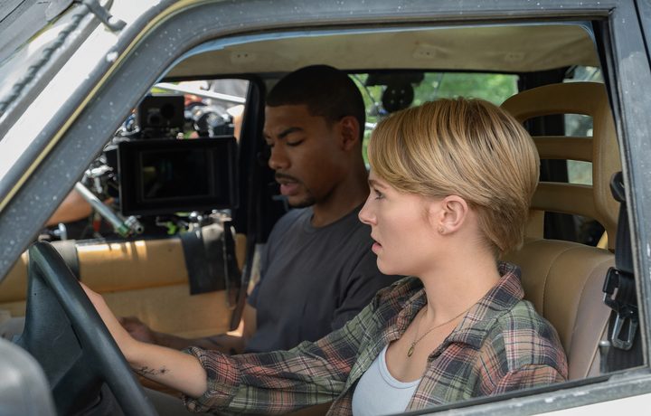 A woman sits in the driver's seat while a man is next to her.