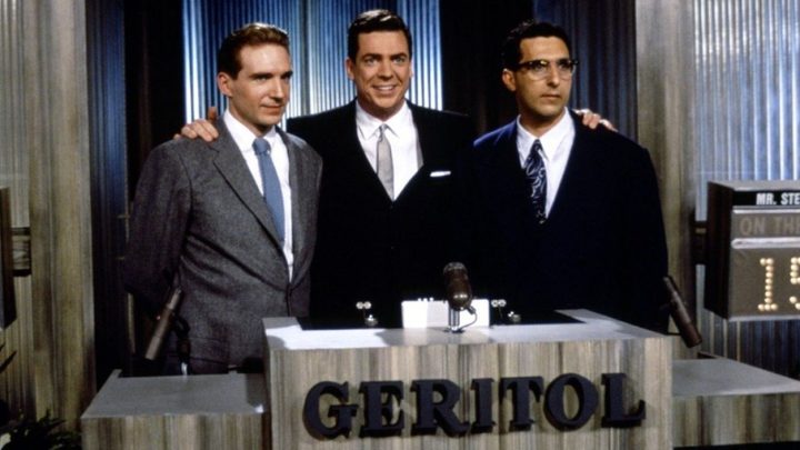 Ralph Fiennes, Christopher McDonald, and John Turturro as Charles Van Doren, Jack Barry, and Herb Stempel posing for a photo in Quiz Show.