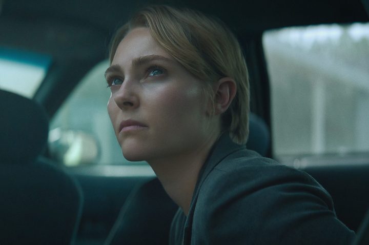 A woman looks up while sitting in the back seat.