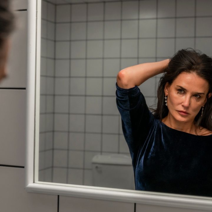 Demi Moore stares into the mirror in a still from the movie The Substance.