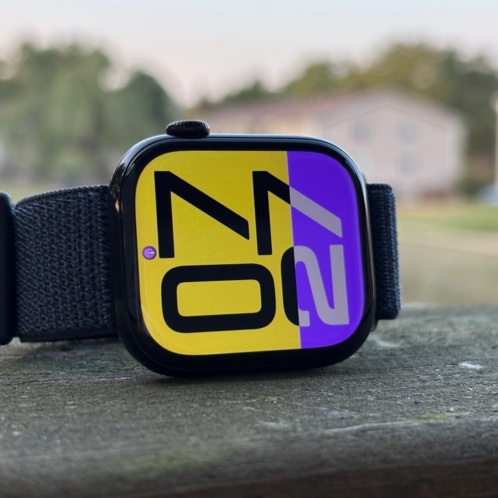 The Apple Watch Series 10 sitting on a railing outside with its screen on.