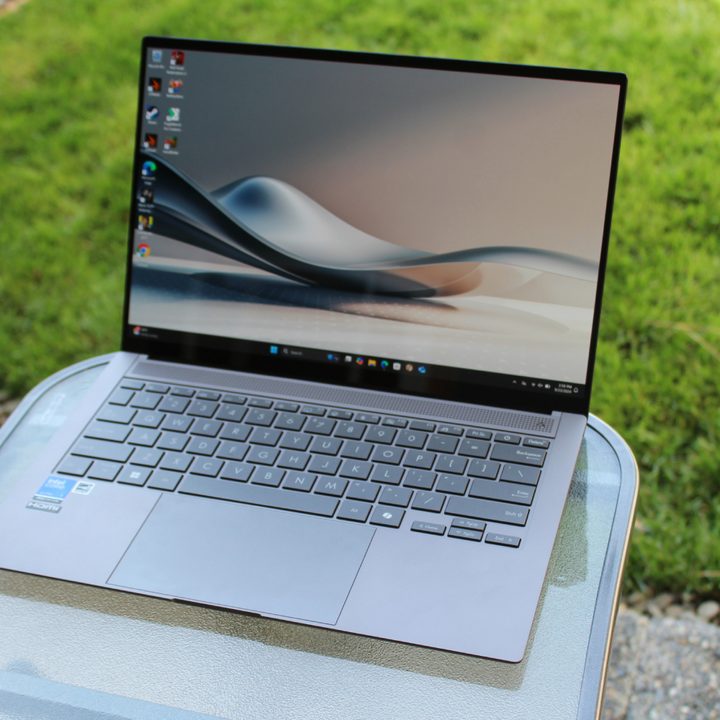 The Asus Zenbook S 14 in front of a grass lawn.